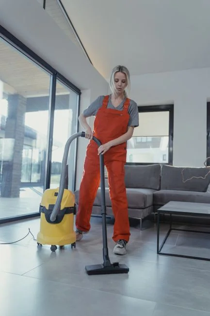Personne utilisant un flacon pulvérisateur et un chiffon pour nettoyer une étagère de cuisine, en veillant à l’hygiène et à la propreté.